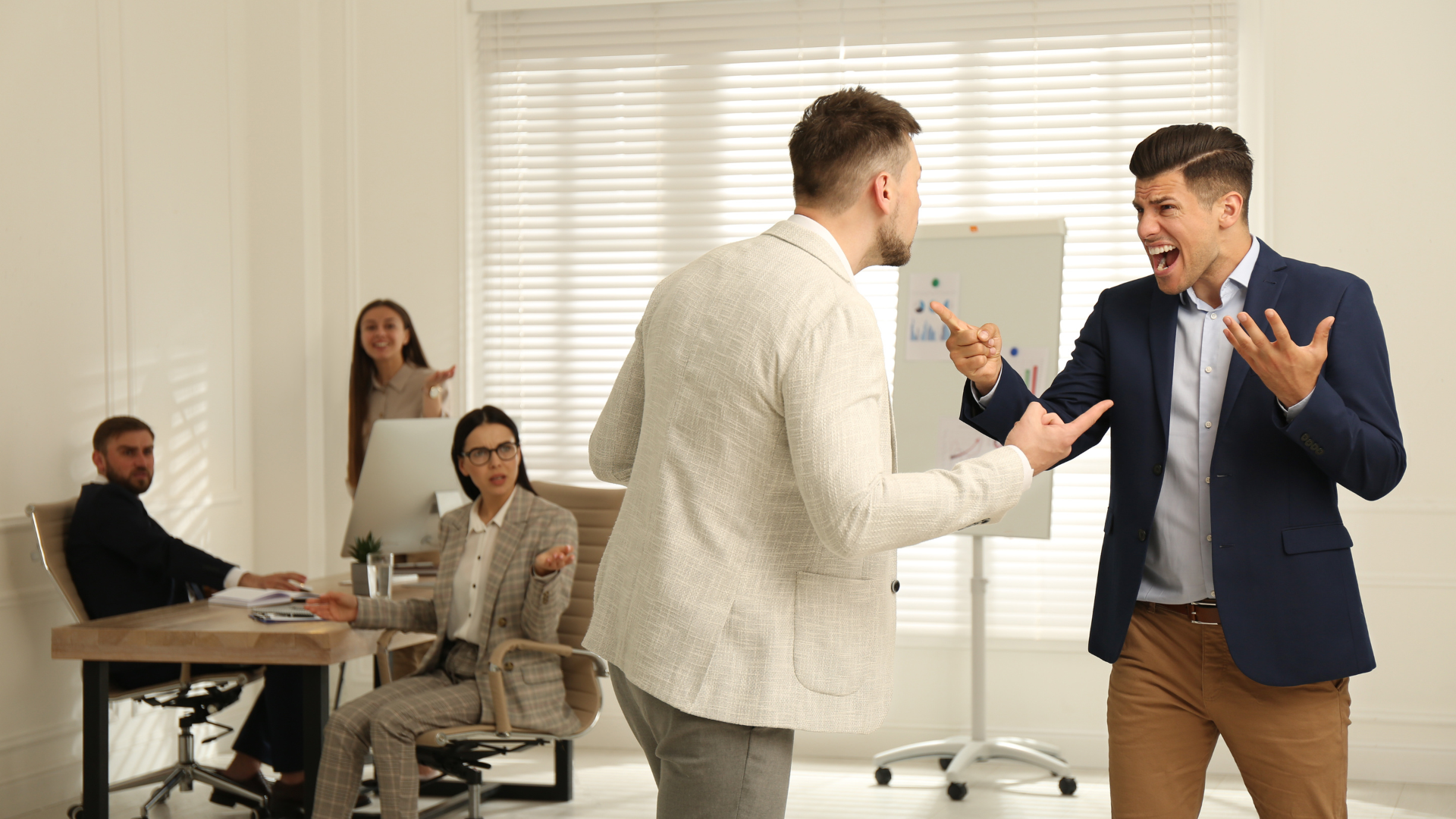 Two male employees arguing at work to symbolise workplace conflict